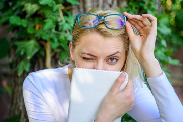 Cute bookworm in eyeglasses enjoy every chapter. Bookworm student relaxing with book green nature background. Woman blonde take break relaxing in park reading book. Girl keen on book keep reading