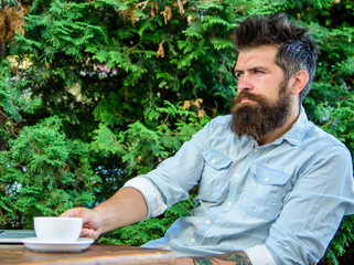 Man bearded businessman sit terrace with laptop and cup of coffee. Freelance benefit. Blogger create post while enjoy coffee. Hipster freelancer work online blog notebook. Create content for web blog