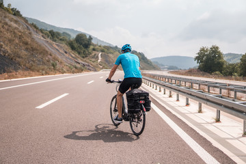 Man riding a bike on an empty highway