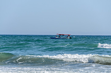 Fototapeta na wymiar Boat near the Beach of Black Sea from Mamaia, Romania, blue clear water