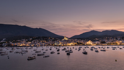 Vista del pueblo de Cadaqués al anochecer con el mar en calma, Costa Brava, Cataluña.España