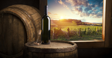 red wine bottle and wine glass on wodden barrel