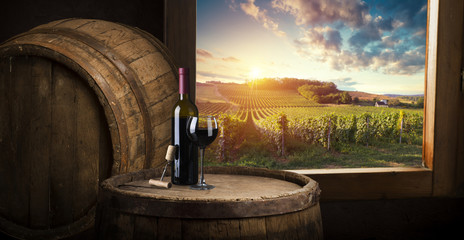 red wine bottle and wine glass on wodden barrel