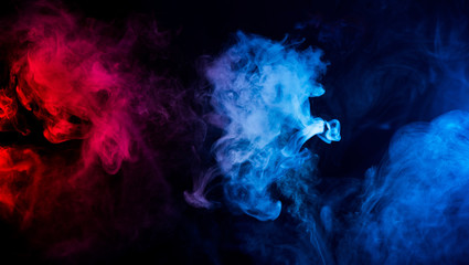 abstract shapes of mixed colors of blue and red smoke at dark background