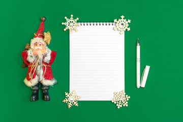 Postcard Happy New Year Flat lay composition with scroll and Christmas decor on green color background.Concept Letter for Santa Claus Greeting Top view Copy space Mock up Empty Text
