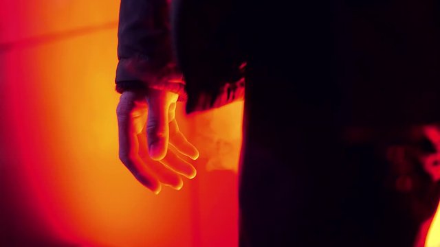 Man in blood red smoke squeezes his hand
