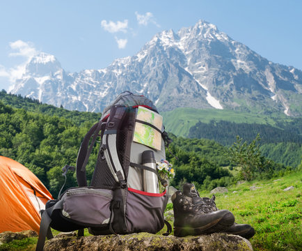 Hiking equipment and camping tent in mountains