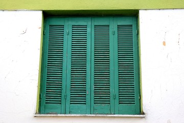 Old wooden green window with shutters. 