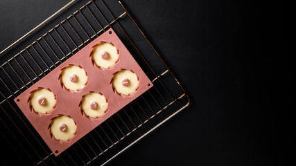 Тесто для Выпечки Кекс или Маффин в силиконовой форме на решётке.Приготовления теста на чёрном фоне.