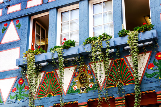 Ein altes Fachwerkhaus mit Blumenschmuck und farbigen Ornamenten in Alsfeld
