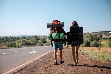 Travel man hitchhiking. Backpacker on road