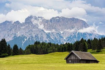 Fototapeta na wymiar Wooden hut near Zugspitze, the highest mountain of Germany at the Bavarian Alps