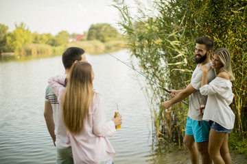 Naklejka premium Young people enjoy fishing on river