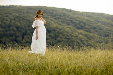 Young pregnant woman relaxing outside in nature
