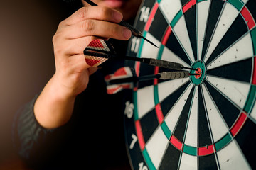 red arrow dart board with hand hold closeup business strategy  concept aim for goal target with...