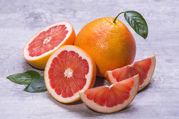 Pieces of ripe juicy grapefruit for raw fresh on a gray background with copy space.