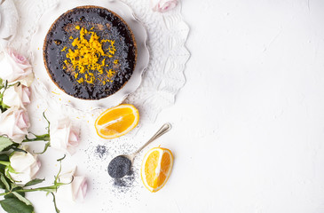 Chocolate cake with orange and icing. On a white background, and a bouquet of white roses. Good morning with a surprise and breakfast. Copy space.