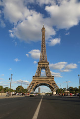 Fototapeta na wymiar Great Eiffel Tower and the street with few cars in Paris