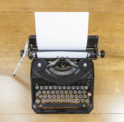 Vintage black typewriter on old oak table.