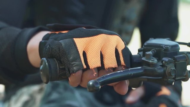 Man puts his hand in sport glove at the rudder