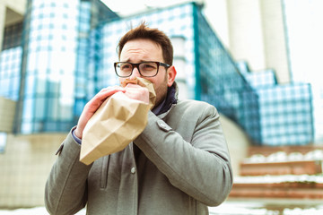 Businessman holding paper bag over mouth as if having a panic attack