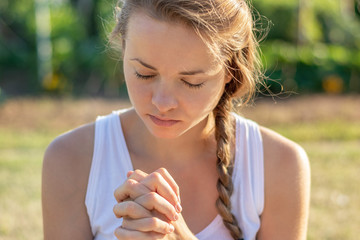 Christian worship and praise. A young woman is praying in the early morning.