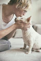 Old woman kissing a dog