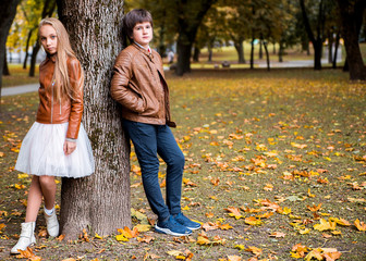 Naklejka premium Boy and girl teenagers in autumn park