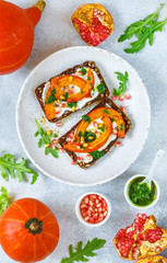 Rye bread sandwiches with baked pumpkin, pesto, arugula, pomegranate seeds and pine nuts. Delicacy appetizer