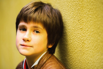 boy teenager posing against a yellow wall background