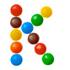 Letter K of sweet colored candies, alphabet isolated on white