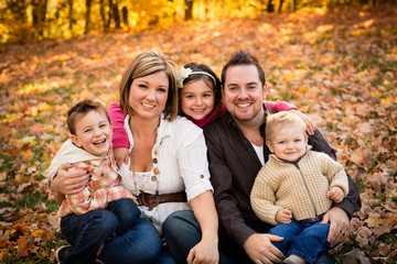 Fototapeta premium Happy Family Sitting Together in Autumn Park
