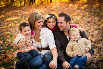Fototapeta premium Happy Family Sitting Together in Autumn Park