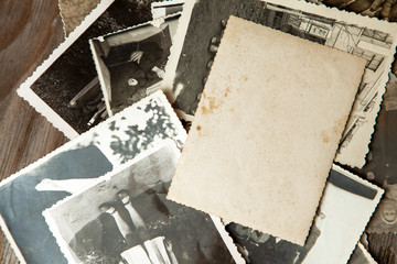 Stack old photos on table. Mock-up blank paper. Postcard rumpled and dirty vintage