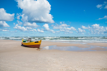 Obraz premium Colorful fishing boat on sandy beach in Debki village. Debki is a very popular holiday destination in Poland. 