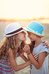     happy friends laugh at the beach on a sunny evening