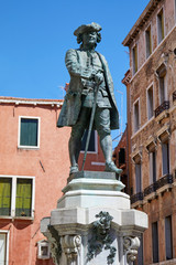 Playwright Carlo Goldoni statue with pedestal by Antonio Dal Zotto (1841-1918) in Venice, clear blue sky in Italy