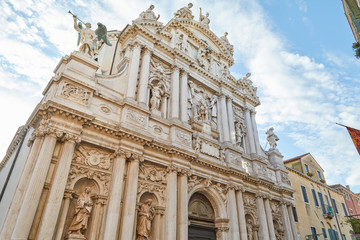 Fototapeta na wymiar Santa Maria del Giglio, low angle view of baroque church facade in a sunny day, white clouds in Italy