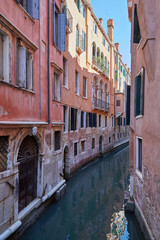 Fototapeta na wymiar Venice narrow canal, ancient buildings and houses facades in Italy, nobody