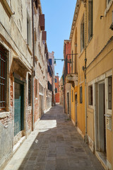 Fototapeta na wymiar Venice alley, buildings and houses facades, nobody in a sunny day in Italy
