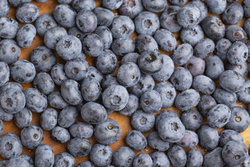 Juicy and fresh blueberries with green mint leaves on a wooden table. Blueberries on wooden background.