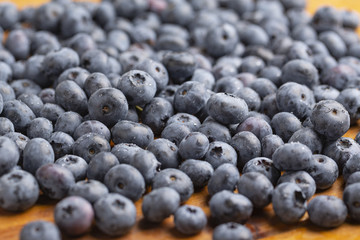 Juicy and fresh blueberries with green mint leaves on a wooden table. Blueberries on wooden background.