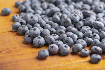Juicy and fresh blueberries with green mint leaves on a wooden table. Blueberries on wooden background.