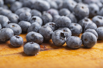 Juicy and fresh blueberries with green mint leaves on a wooden table. Blueberries on wooden background.