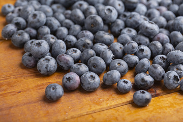 Juicy and fresh blueberries with green mint leaves on a wooden table. Blueberries on wooden background.