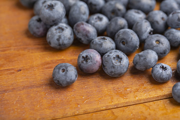 Juicy and fresh blueberries with green mint leaves on a wooden table. Blueberries on wooden background.