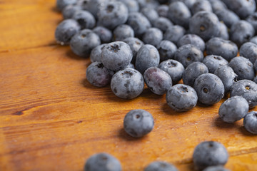 Juicy and fresh blueberries with green mint leaves on a wooden table. Blueberries on wooden background.