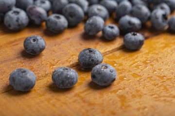 Juicy and fresh blueberries with green mint leaves on a wooden table. Blueberries on wooden background.