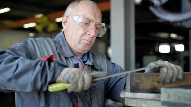An elderly man in production. The worker will have a file.