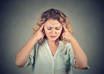 Concentrating beautiful woman holding fingers on temples